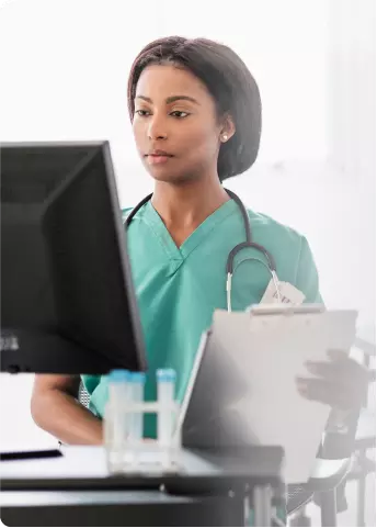 Healthcare provider looking at a computer screen to acquire product through buy and bill